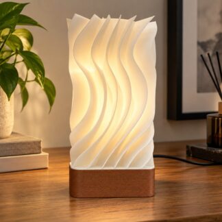 3D Printed φωτιστικό Wave Light με λευκό κυματιστό σώμα, καφέ βάση και φωτισμό σε ξύλινο μπουφέ